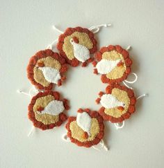 four red and white lion ornaments hanging on a wall