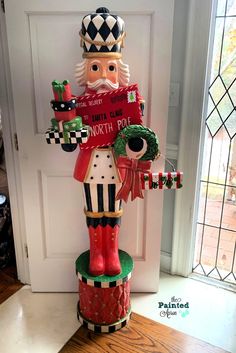 a christmas nutcracker standing in front of a door with the words north pole painted on it