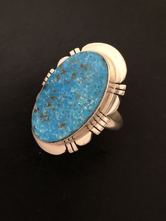 "This Turquoise gemstone is intriguing with its matrix. The Turquoise is Kingman Turquoise and has a deep blue Turquoise. Kingman Turquoise is found just off the highway about 20 miles Northwest of Kingman, Arizona. This is the highway to Las Vegas, Nevada. The ring is stamped, Sterling Silver and Paul Sanchez the artist Hallmark. Paul is a well-known silversmith and lives in the Albuquerque, New Mexico area. The ring weighs 10.22 grams and the ring measures 1 1/8\" X 7/8\" in size. This stunnin Southwestern Chrysocolla Gemstone Rings, Southwestern Turquoise Chrysocolla Ring, Southwestern Chrysocolla Turquoise Ring, Collectible Untreated Blue Turquoise Ring, Artisan Turquoise Ring With Chrysocolla, Southwestern Style Untreated Blue Turquoise Ring, Southwestern Blue Oval Jewelry, Southwestern Style Blue Oval Jewelry, Blue Oval Southwestern Jewelry