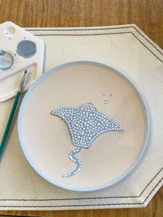 a blue and white plate sitting on top of a table next to a pair of scissors