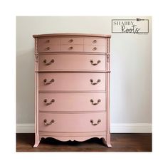 a pink chest of drawers sitting on top of a wooden floor