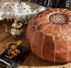 a brown leather poufce sitting on top of a rug next to other items