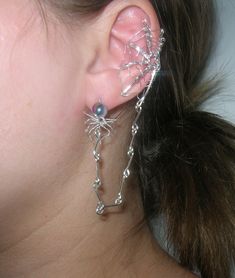 A beautiful spider web ear cuff with a connected spider earring! It hangs on the outside of whichever ear you want and can be bent to fit anyone's size of ear. If you want a pair pick quantity as two. The wire is silver plated with a two color toned glass bead for the spider! A made to order piece just in time for Halloween! You'll be able to customize this with different color beads and kinds of wire.  Note: If you want the spider to just dangle and not go into the earlobe. Just message me with your order and I will customize that for you! Thank you! Silver Fantasy Ear Cuff For Party, Halloween Silver Body Jewelry Gift, Fantasy Silver Ear Cuff For Party, Silver Punk Jewelry For Cosplay, Silver Body Jewelry For Halloween, Nickel-free Gothic Silver Body Jewelry, Nickel-free Silver Gothic Body Jewelry, Gothic Nickel-free Silver Body Jewelry, Gothic Silver Jewelry For Cosplay