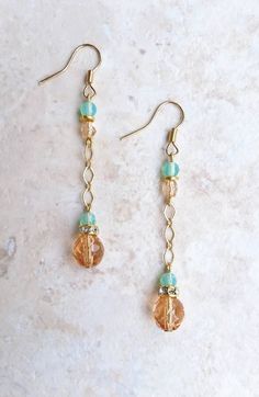 "Translucent peach and milk sea green Czech glass beaded satin gold chain drop earrings with crystal rhinestone gold spacers A little bit peachy and a little bit beachy, these simple and versatile drop earrings are the perfect summer accessory! Whether you're going to a movie in the park or a wedding on the beach, their classic minimalist design make these earrings both versatile and elegant. From a gold plated earwire hangs 4mm milky sea green and faceted pink Czech glass beads separated by a bright golden brass spacer bead.  From these beads dangle an 8mm faceted translucent peach and a 4mm faceted seafoam green Czech glass bead on a satin gold diamond link chain. A 5mm gold plated crystal rhinestone spacer separates the two focal beads and adds just enough sparkle to make these simple b Trendy 14k Gold Filled Dangle Jewelry, Gold Dangle Earrings With Beaded Chain, 14k Gold-filled Beaded Drop Earrings, Adjustable Gold Earrings With Beaded Chain, Beaded 14k Gold Filled Dangle Earrings, 14k Gold Filled Beaded Dangle Earrings, Rose Gold Jewelry With Dangling Beads For Gift, Wire Wrapped Czech Glass Drop Earrings, Dainty Gold Beaded Earrings