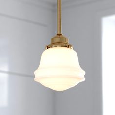 a light fixture hanging from the ceiling in a room with white walls and flooring