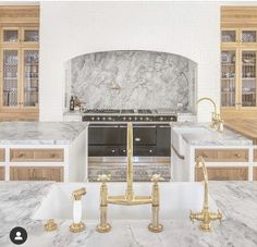 a kitchen with marble counter tops and gold faucets