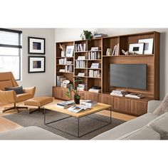 a living room filled with furniture and a flat screen tv sitting on top of a wooden shelf