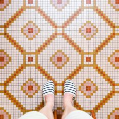 a person standing in front of a tiled floor with their feet up on the ground