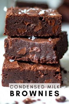 three chocolate brownies stacked on top of each other with the words condenseed milk above them