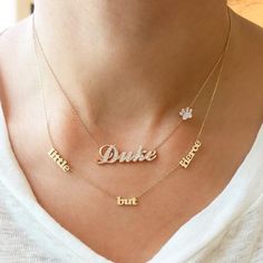 This unique personalized script font triple name cut-out necklace is composed of 14K solid gold and beautifully complemented by a delicate yet durable 14K solid gold chain. This sentimental piece is adjustable in length, from 14 to 16 inches or 16 to 18 inches. NOTE: The item will be made in the exact casing of the characters entered. Please be mindful of this detail when providing the customization desired. Name Dimensions: approximately 4mm high x width depending on the names desired Pendant T Block Font, Family Necklace, Solid Gold Necklace, Solid Gold Chains, Charm Pendant Necklace, Script Font, Unique Necklaces, Gold Charm, Real Diamonds