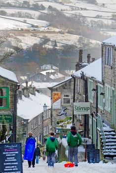 people walking down a snow covered street in the winter