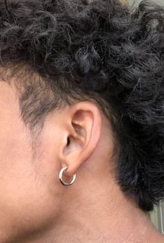 the back of a person's head with an earring on it and hair in front of them