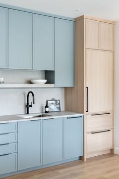 a kitchen with light blue cabinets and white counter tops is pictured in this image from the front view