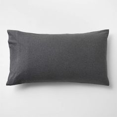 a dark gray pillow on a white wall