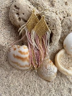 shells and beads are laying on the sand