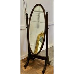 an old fashioned mirror is sitting on a stand