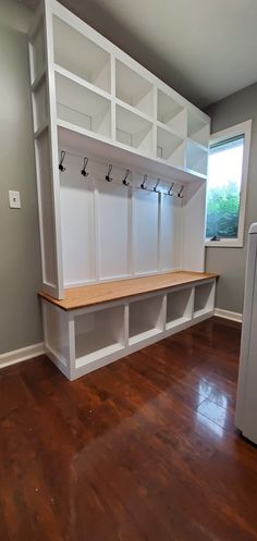 an empty room with white shelves and wooden floors