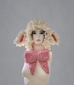 a mannequin head wearing a pink and white knitted hat with large ears