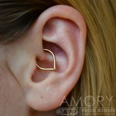 a woman's ear is shown with a gold nose ring