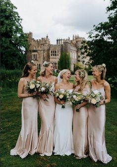 a group of women standing next to each other in front of a castle