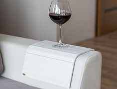 a glass of wine sitting on top of a white couch