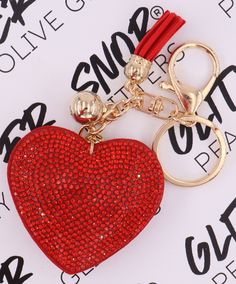 a red heart shaped keychain sitting on top of a piece of paper