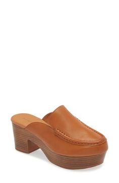 A moc toe and loafer-inspired topline add sophisticated elements to a leather mule lofted by a chunky platform and block heel. 3" heel; 1 1/4" platform Cushioned footbed Leather upper and lining/rubber sole Imported Modern Brown Platform Loafers With Leather Sole, Brown Almond Toe Mules With Sculpted Heel, Brown Square Toe Mules With Stacked Heel, Classic Brown High Heel Mules, Formal Brown Mules With Stacked Heel, Brown Mules With Sculpted Heel For Work, Classic Almond Toe Clogs For Workwear, Leather Loafers With Wooden Heel For Work, Classic Workwear Clogs With Almond Toe