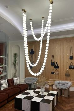 a living room filled with lots of furniture and hanging beads on the wall above it