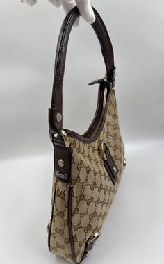 A stunning vintage Gucci trapeze shoulder bag made from the iconic GG beige canvas with brown leather trim and Gucci branded pale gold hardware. Inside the bag is lined with brown cotton lining and there is a zipped pocket for valuables. This bag is in good vintage condition with some slight wear to the leather parts. Made in Italy. Height: 24cm Width: 30cm Depth: 5cm To ensure you’re completely satisfied with your purchase, please refer to the images for the exact condition of the item. Gucci Brand, Gucci Shoulder Bag, Pale Gold, Vuitton Bag, Baby Bag, Leather Trim, Vintage Gucci, Leather Trims, Exclusive Designs