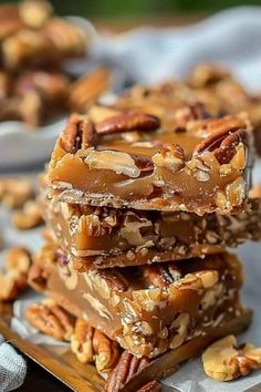 three pieces of pecan bar stacked on top of each other with nuts around them