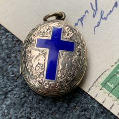 "This antique locket is so stunning and of the highest craftsmanship and quality.  The condition is incredible for its age with all the blue cross enamel still intact.  The locket is 14k gold filled and is engraved with an ivy leaf motif on both of the front and back.  The back includes a small area on the bottom for engraving and is still blank.  The inside features the original blue fabric and would likely have been used either for photos or as a mourning piece featuring a locket of a loved on Blue Engraved Jewelry For Wedding, Blue Medallion Jewelry For Anniversary, Blue Engraved Jewelry For Keepsake, Blue Locket Jewelry For Wedding, Blue Locket Jewelry For Anniversary, Formal Blue Locket Jewelry, Blue Engraved Necklace For Keepsake, Blue Medallion Jewelry With Polished Finish, Antique Blue Engraved Jewelry