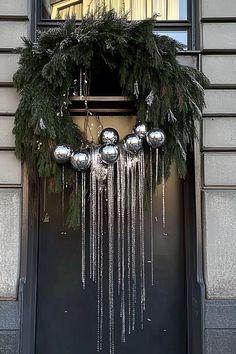 a christmas wreath hanging on the front door of a building with snow and icicles all over it