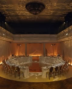 an empty banquet hall with tables and chairs set up for a formal function in the evening