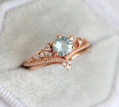 an engagement ring with a blue topaz surrounded by diamond accents on a white cloth