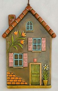 a ceramic house ornament hanging on a wall