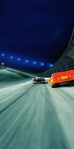 two cars driving down a snowy road at night