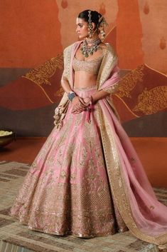 Pretty in gulab blush, the gulab barfi lehenga is intricately crafted with tropical motifs like sehra and amaltas. Finished with our berry bel motif border, it adds a whimsical touch that's iconic to a Masaba bride. Brought to life with age-old crafts like zardozi and sitara embroidery, it is paired with a heavily embellished blouse. The ensemble is further styled with an additional veil adorned with dainty embroidery work, making this look perfect for any bride. It also comes with a separate ca Pink Palazzo Set With Dori Work, Bollywood Style Pink Palazzo Set With Pallu, Pink Palazzo Set For Diwali, Traditional Pink Palazzo Set For Reception, Pink Sharara For Navratri, Pink Anarkali Choli With Cutdana, Pink Sharara For Reception Navratri, Pink Palazzo Set With Dori Work For Navratri, Designer Pink Lehenga With Sheer Dupatta