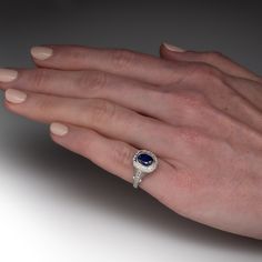 a woman's hand with a ring on it and a blue stone in the middle