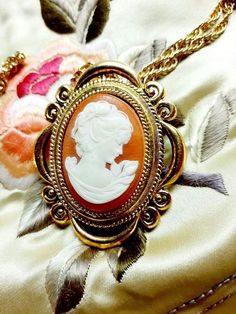 A large pretty 1970s vintage Victorian look cameo solid perfume locket by Max Factor that was never used. This large lovely cameo locket necklace is filled with solid perfume and has a delicate carved plastic cameo on the front.A bright gold tone Victorian style setting makes it a romantic piece to wear.The original gold tone link necklace chain is included.The locket is 2" x 1 1/2"The chain is 13 1/2" long. The solid cream perfume inside hasn't been touched and it still smells lovely. It is ver Gold Cameo Locket Necklace For Wedding, Victorian Cameo Locket Necklace As A Gift, Vintage Medallion Cameo Locket Necklace, 70s Victorian, Victorian Oval Cameo Locket Necklace, Cream Perfume, Cameo Locket, Victorian Gold Cameo Locket Necklace, Perfume Locket