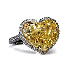 a heart shaped yellow diamond ring with diamonds around it