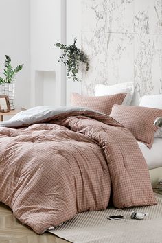 a bed with pink comforter and pillows in a room