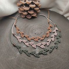 a pine cone sitting on top of a wooden table next to some beads and chains