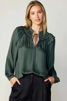 A gathered yoke and layered ruffles at the shoulders heighten the feminine charm of this breezy blouse. It's cut for a loose, relaxed silhouette and features a split neckline, self-tie detailing, and long sleeves with elasticized cuffs.  •Split neckline with self-tie •Gathered yoke •Ruffle trim •Long sleeves with elast Billowy Long Sleeve Peasant Top With Ruffles, Chic Flowy Blouse With Split Neck, Chic Flowy Split Neck Blouse, Casual Ruffled Split Neck Blouse, Chic Fall Peasant Top With Ruffles, Fall Long Sleeve Peasant Top With Ruffles, Flowy Smocked Bodice Blouse For Fall, Chic Long Sleeve Blouse With Smocked Bodice, Feminine Long Sleeve Peasant Top With Ruffles