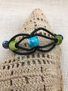 This multicolored boho style handmade beaded cord bracelet is done in colors of blues and green beads on black leather cord. It is a casual piece of jewelry that is a great gift idea for ladies or girls of any age. It is approximately 8 inches in length with a toggle clasp and is made in the USA. Other colors are available. * can also be custom ordered for a man's wrist Multicolor Adjustable Beaded Bracelets, Multicolor Beaded Bracelets With Adjustable Waxed Cord, Multicolor Beaded Bracelets With Adjustable Cord, Green Beaded Bracelet With Adjustable Cord For Festival, Green Adjustable Cord Beaded Bracelet For Festival, Green Adjustable Cord Beaded Bracelets For Festivals, Handmade Blue Leather Bracelet For Festival, Handmade Multicolor Leather Bracelet Casual Style, Adjustable Blue Beaded Bracelets Hippie Style