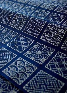 a close up view of a blue and white quilt with intricate designs on it's edges