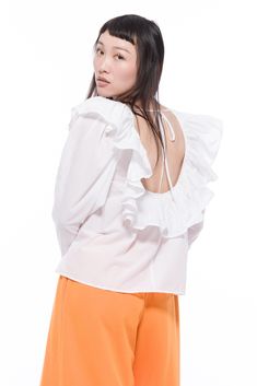 Our Cynthia Top is perfect for all your vintage styling dreams this summer. Inspired by the 80's, it features a darling ruffle neckline. Fabricated with a delicate 100% cotton lawn. We left an open tie back detail for something extra. White Ruffle Tie Neck Tops, White Ruffled Tie-neck Tops, Feminine Off-white Top With Ruffles, Brown Converse, Chic Smocked V-neck Top With Ruffles, Summer Embroidered V-neck Top With Ruffles, Garment Workers, Cuff Detail, Tapered Jeans