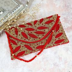 Featuring a Red Antique Gold Clutch bag in cotton base with a flap opening with a cut dana beaded strap, Handcrafted with Intricate Stone, beaded crystal, Cut dana and rhinestones.  Bag Measuring 26cm in length and 13cm in width. When your outfit could use a final, eye-catching addition, make sure the Fancy Fab's 'Zaina' Red Antique Gold Clutch is on-hand!  Perfect for evening parties and a special occasion.  This item made of is 100% handwork We try to take pictures as normal as we can but colo Gold Clutch Bag, Bridal Clutch Bag, Zardosi Work, Beaded Strap, Couture Embroidery, Gold Clutch, Bridal Clutch, Pakistani Jewelry, Nose Jewelry