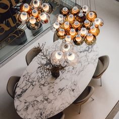 a marble dining table surrounded by chairs and candles