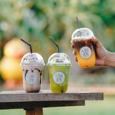 three different types of drinks sitting on top of a wooden table next to each other