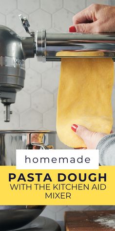 homemade pasta dough being made with the kitchen aid mixer and hand on top of it